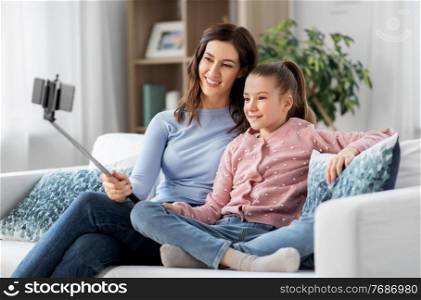 family, technology and people concept - happy mother and daughter with smartphone taking selfie at home. happy family taking selfie by smartphone at home