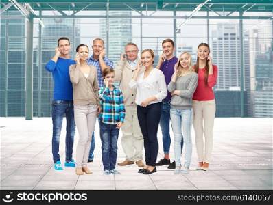 family, technology, generation and people concept - group of smiling men, women and boy with smartphones calling over terminal with window city view background