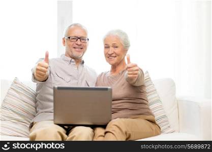 family, technology, gesture, age and people concept - happy senior couple with laptop computer showing thumbs up at home