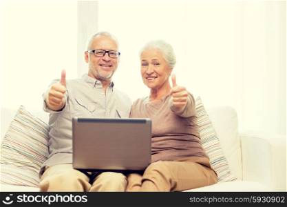 family, technology, gesture, age and people concept - happy senior couple with laptop computer showing thumbs up at home