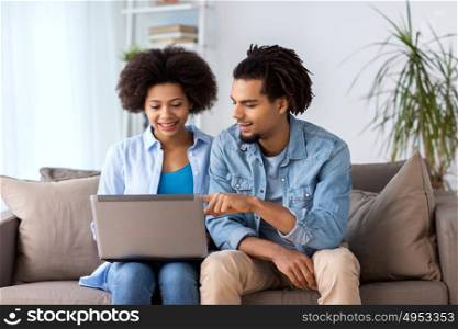 family, technology, internet and people concept - smiling happy couple with laptop computer at home. smiling happy couple with laptop at home