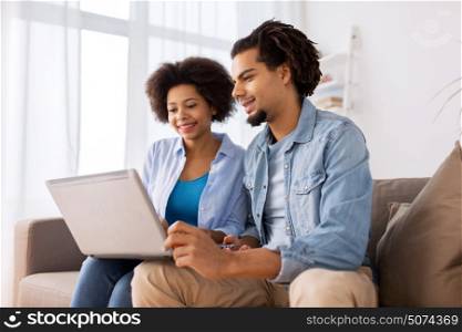 family, technology, internet and people concept - smiling happy couple with laptop computer at home. smiling happy couple with laptop at home