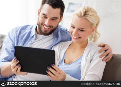 family, technology, internet and people concept - smiling happy couple with tablet pc computer at home. smiling happy couple with tablet pc at home
