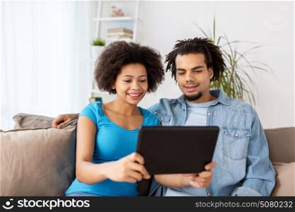family, technology, internet and people concept - smiling happy couple with tablet pc computer at home. smiling happy couple with tablet pc at home