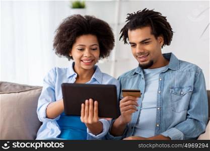 family, technology, online shopping and people concept - smiling happy couple couple with tablet pc computer and credit card at home. couple with tablet pc and credit card at home