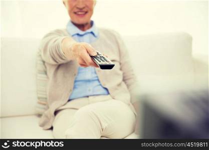 family, technology, television, age and people concept - close up of happy senior woman watching tv at home