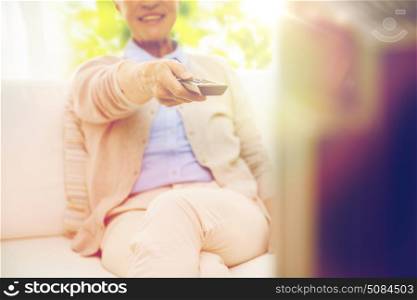family, technology, television, age and people concept - close up of happy senior woman watching tv at home. close up of happy senior woman watching tv at home. close up of happy senior woman watching tv at home