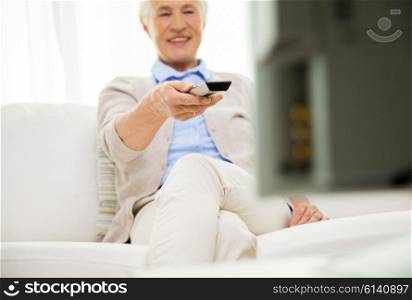 family, technology, television, age and people concept - close up of happy senior woman watching tv at home