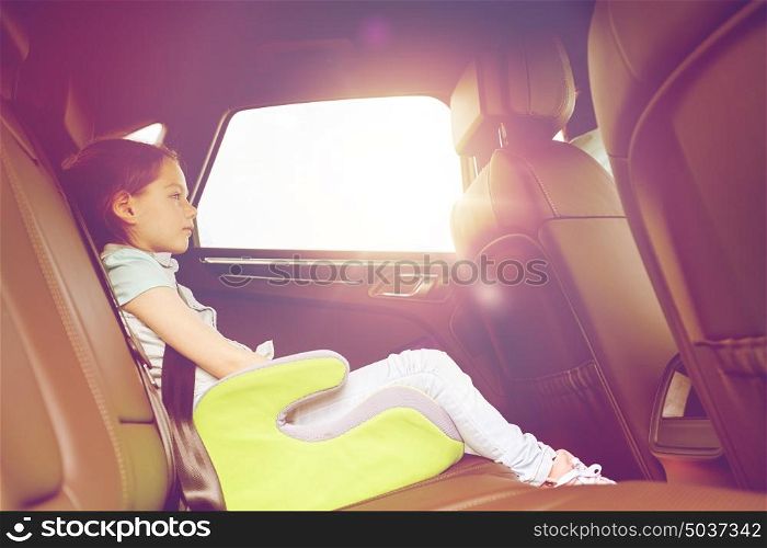 family, transport, road trip and people concept - happy little girl in safety seat driving in car. family with child in safety seat driving car