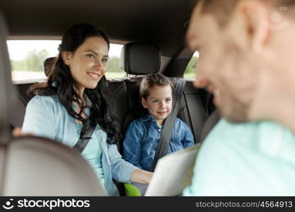 family, transport, road trip and people concept - happy woman and little daughter with map driving in car