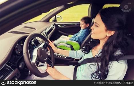 family, transport, road trip and people concept - happy woman with little daughter driving in car. happy woman with little child driving in car