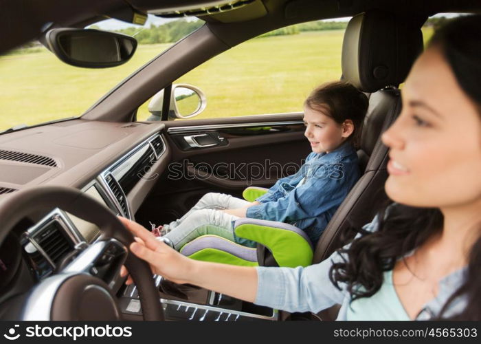 family, transport, road trip and people concept - happy woman with little girl driving in car