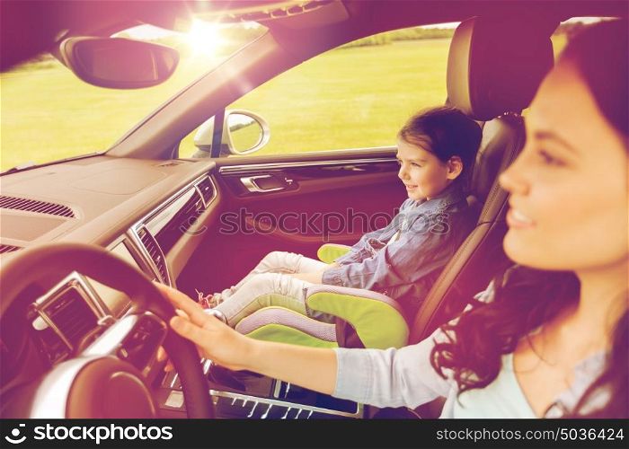 family, transport, road trip and people concept - happy woman with little girl driving in car. happy woman with little girl driving in car
