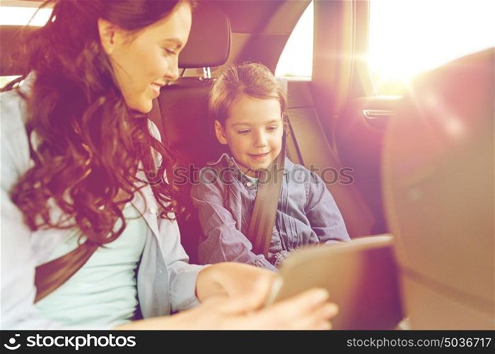 family, transport, road trip, travel and people concept - happy woman and little daughter with tablet pc computer driving in car. happy family with tablet pc driving in car