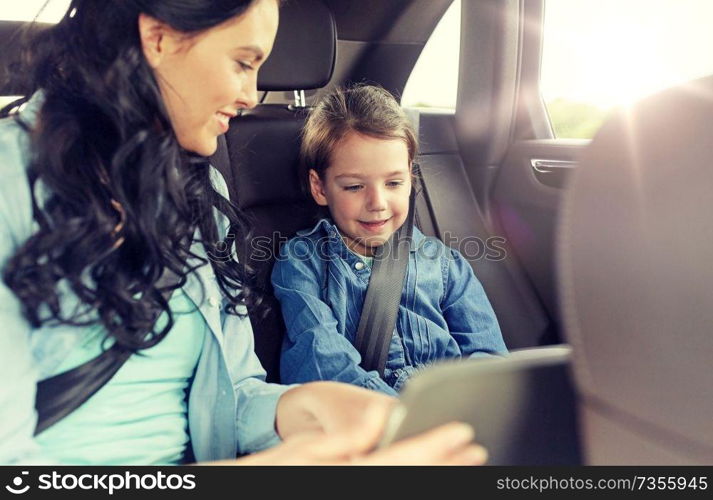 family, transport, road trip, travel and people concept - happy woman and little daughter with tablet pc computer driving in car. happy family with tablet pc driving in car