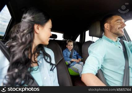 family, transport, safety, road trip and people concept - happy man and woman with little child driving in car