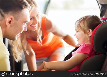 family, transport, safety, road trip and people concept - happy parents talking to little girl in baby car seat