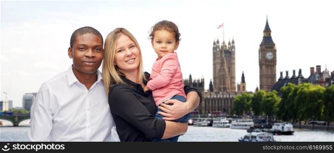 family, travel, tourism and international concept - happy multiracial mother, father and little child over london city background