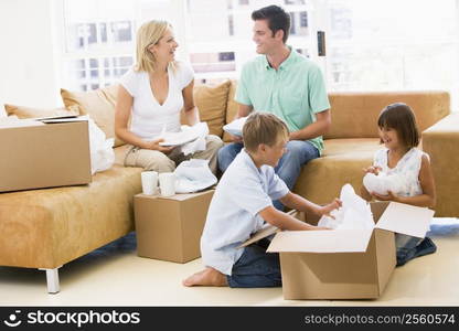 Family unpacking boxes in new home smiling