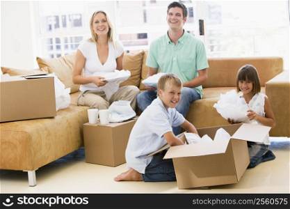 Family unpacking boxes in new home smiling