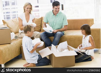 Family unpacking boxes in new home smiling