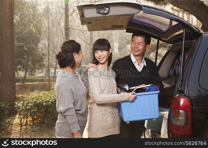 Family unpacking minivan for college, Beijing