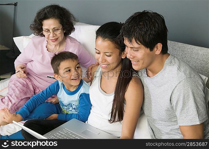 Family Using Laptop on Couch