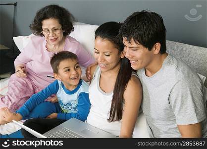 Family Using Laptop on Couch