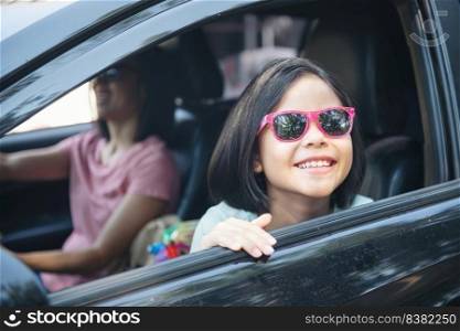 Family vacation holiday, happy family on a road trip in their car, mom driving car while her daughter sitting beside, mom and daughter are traveling. summer ride by automobile.