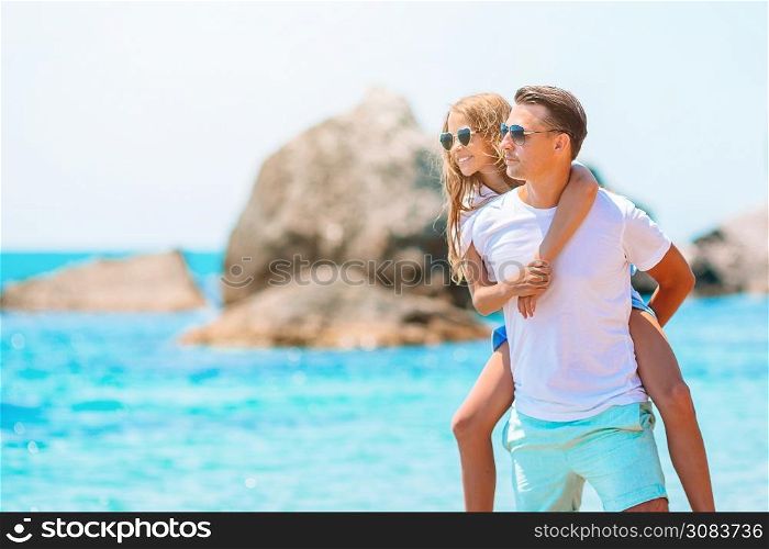 Family vacation. Little adorable girl and young father on the beach. Little girl and happy dad having fun during beach vacation