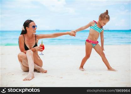 Family vacation. Mother and little daughter on vacation on the beach. Adorable little girls and young mother on tropical white beach