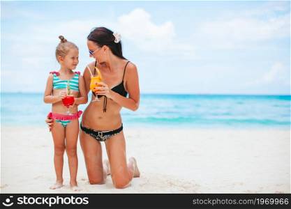 Family vacation. Mother and little daughter on vacation on the beach. Adorable little girl and young mother on tropical white beach