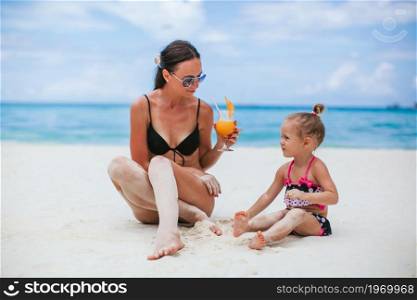 Family vacation. Mother and little daughter on vacation on the beach. Adorable little girls and young mother on tropical white beach