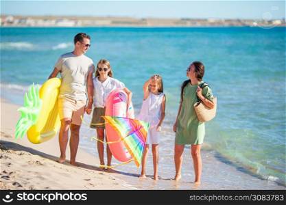 Family vacation. Parents with kids on the beach ready to swim. Young family on vacation have a lot of fun