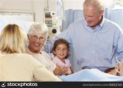 Family Visiting Senior Female Patient In Hospital Bed