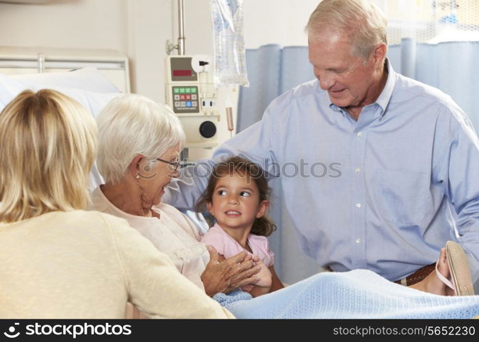 Family Visiting Senior Female Patient In Hospital Bed