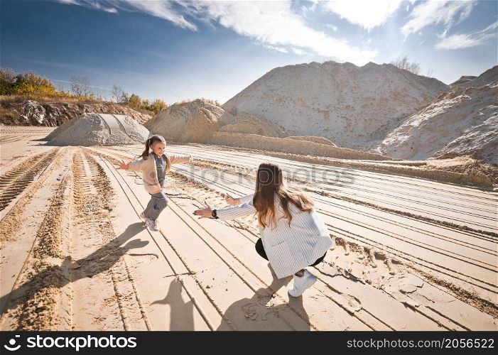 Family walk among the sand.. Mom and daughter are running among the mountains of sand 3321.