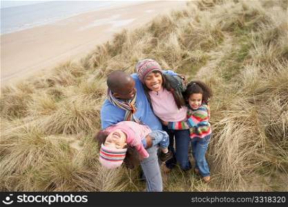 Family Walking Along Dunes On Winter Beach