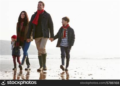 Family Walking Along Winter Beach