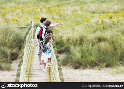 Family Walking Along Wooden Bridge