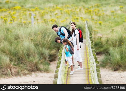 Family Walking Along Wooden Bridge