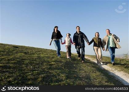 Family walking hand in hand on hill