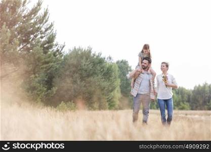 Family walking on field at farmland