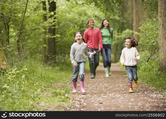 Family walking on path holding hands smiling