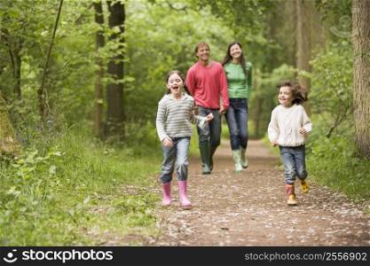 Family walking on path holding hands smiling
