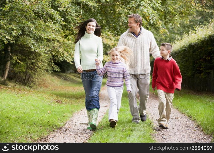 Family walking on path outdoors smiling (selective focus)