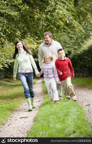 Family walking on path outdoors smiling (selective focus)