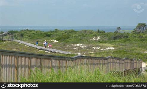 Family walking out to Ho Hum beach on Fire Island