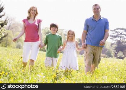 Family walking outdoors holding flower smiling