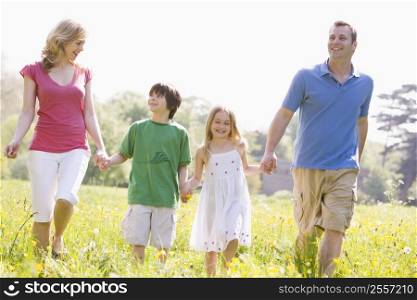 Family walking outdoors holding flower smiling